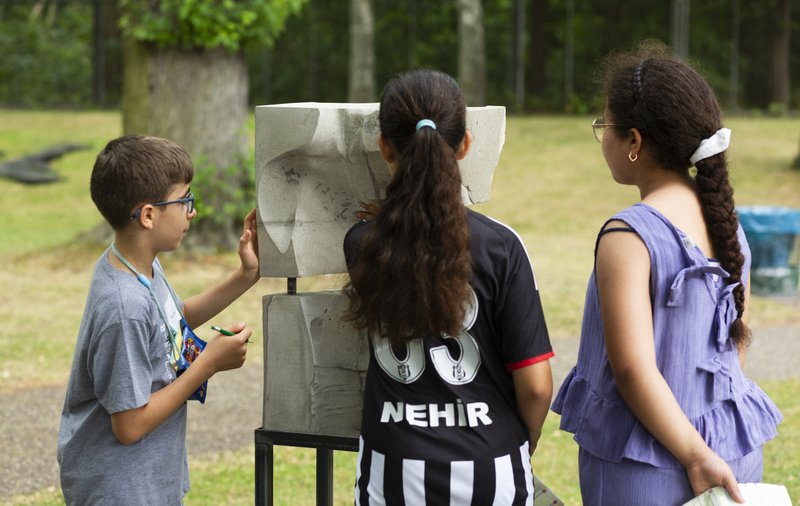 Die Kinder-Jury schaut sich ein Kunstwerk aus der Ausstellung PRÉSENT an