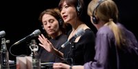 Mieko Kawakami gestikulierend und sitzend vor einem Mikrofon